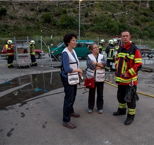 Hochwasser in Kleinlützel: Lilli Kuonen (Mitte) und Juliana Nufer vom RFS besprechen die Lage mit Toni Müller, Kommandant Feuerwehr Kleinlützel. Foto: Martin Staub

