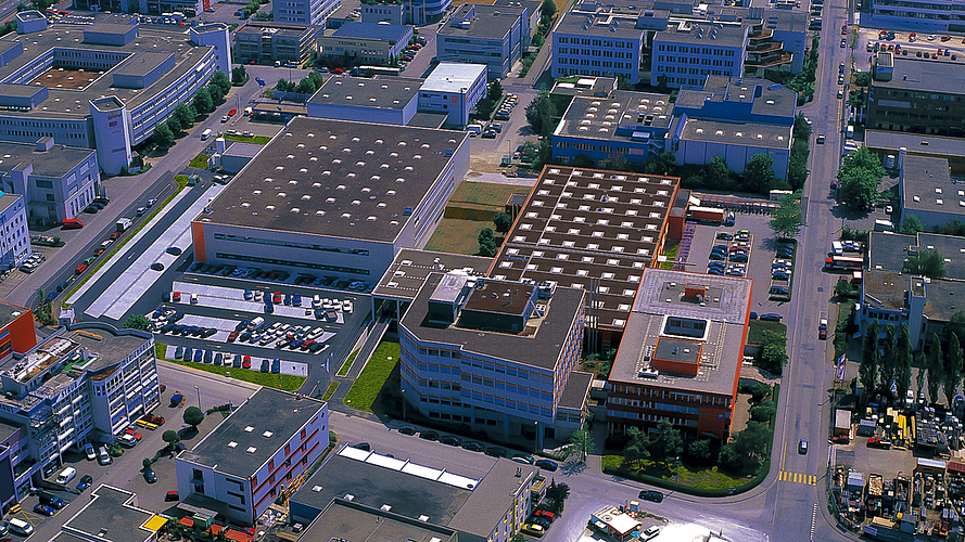 Endress + Hauser wächst weiter: Das orange Gebäude Ecke Kägenstrasse/Christoph-Merian-Ring (unten rechts) wird ersetzt, ein zweites Gebäude wird auf dem dahinter liegenden Parkplatz errichtet.  Fotos: ZVG
