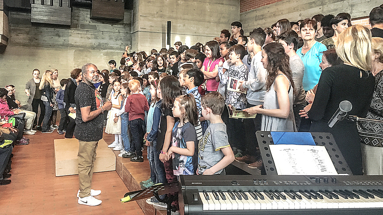 Vor dem Auftritt: Gospelsänger Michael Crews stimmt die Kinder mit einem kleinen Einsingen für das Konzert im Mischeli ein.  Foto: Caspar Reimer