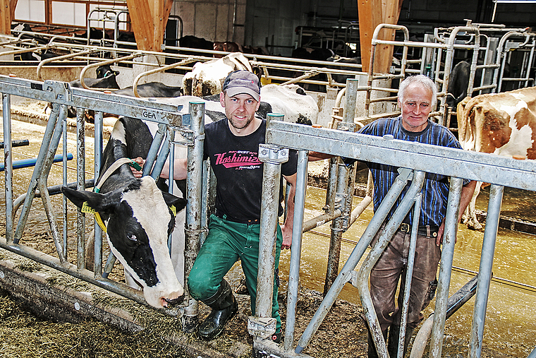 Die beiden Bauern der Betriebsgemeinschaft Langackerhof: Thomas Vögtli (r.) und Seppi Vögtli mit Kuh Lindsey.  Foto: Benildis Bentolila.