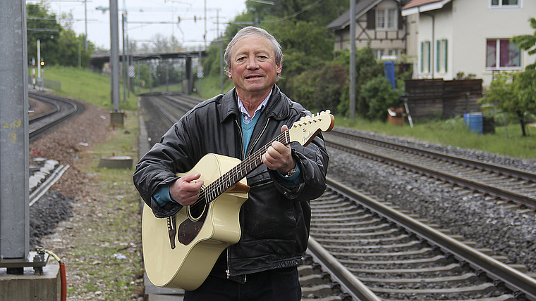 Musik im Blut: Während des Posierens mit der Gitarre beim Bahnhof Dornach beginnt Peter Felix auf seiner Gitarre zu spielen. Foto: Tobias Gfeller
