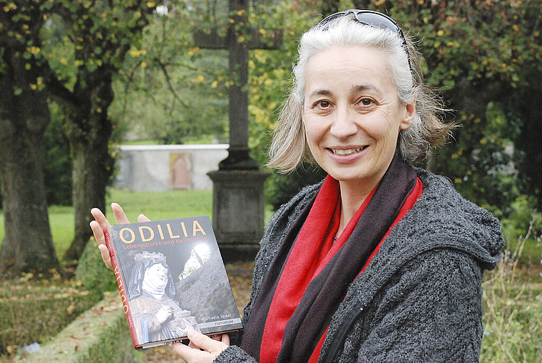 Druckfrisch: Bei den Linden des Bauerngartens, den Bäumen der heiligen Odilia, präsentiert Autorin Michaela Spaar ihr Buch. Foto: Thomas Brunnschweiler