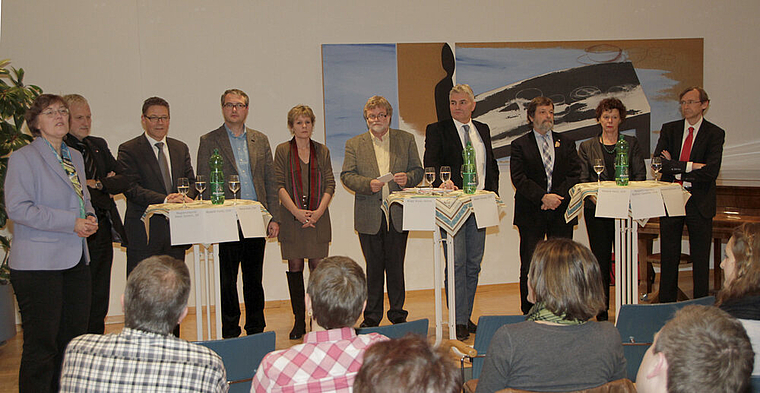 Organisatorin, Kandidierende und der Moderator: Susanne Koch (l.) führte in das Podium ein, stellte die Kandidatinnen und Kandidaten und den Moderator Heiner Leuthardt (6. v. l.) vor. 
