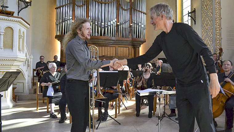 Solist und Dirigent: Das Orchester Arlesheim überzeugte unter Markus Teutschbein und mit Soloposaunist Lucas Tiefenthaler.  Foto: Gilles Hauert