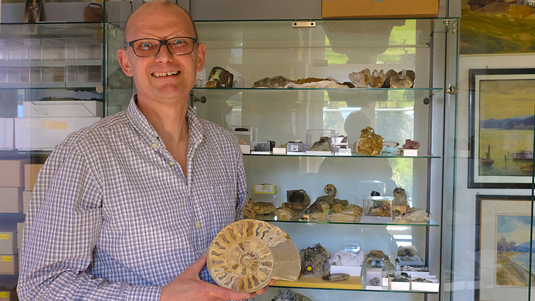 Präsentiert einen aufgeschnittenen Ammoniten: Patrick Gasser in seinem Arbeitszimmer.  Foto: Thomas Brunnschweiler