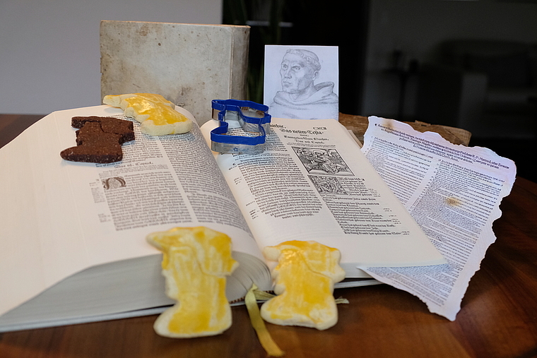 Reformation auf einen Blick: Das blaue «Re-Förmchen» samt Zwingli-Gutzi, die Zürcher Bibel von 1531 und der Mönch Martin Luther mit seinen 95 Thesen von 1517. Foto: Thomas Brunnschweiler