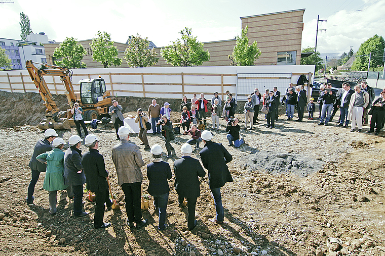 Bei Sonnenschein: Mit dem Spatenstich der Offiziellen kommt der Kulturbau definitiv in die Gänge. Der Theaterzug des Neuen Theaters am Bahnhof wird nach seinem Zwischenhalt in Arlesheim wieder in Gleisnähe stehen. Foto: Lukas Hausendorf