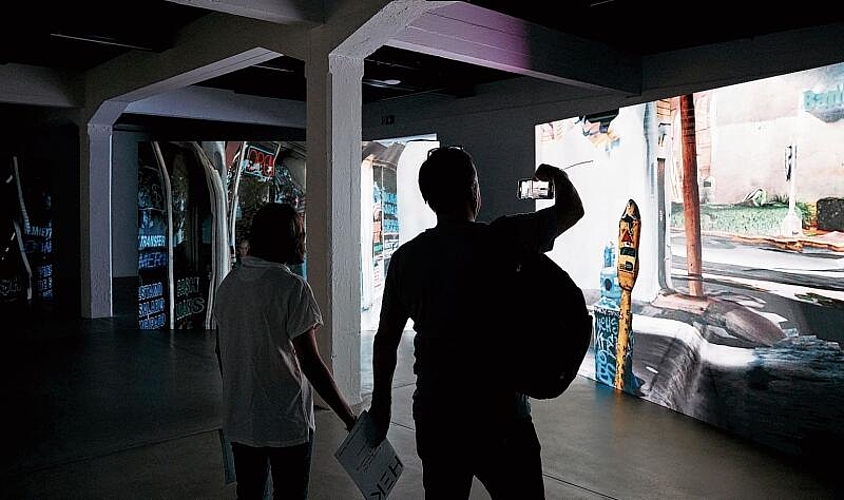 Dystopisches Miami: Besucher schauen sich das Werk «The Sky Is on Fire» während der Vernissage der Ausstellung «Seeing ist Revealing» im Haus der elektronischen Künste an. Foto: zVg/Moritz Schermbach
