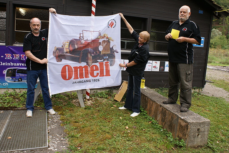 Das Geschenk: Fahnengötti und -gotte Heimo und Gret Klötzli entrollen die von ihnen gespendete Omeli-Fahne, Präsident Hansjörg Gygi hält die Laudatio. Foto: Jürg Jeanloz