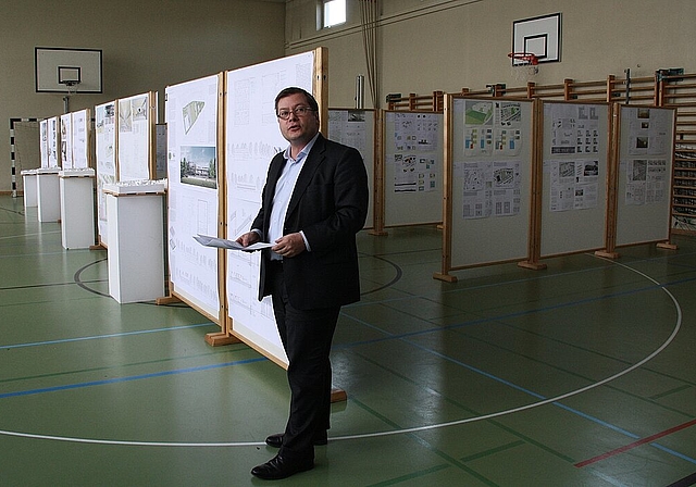 Ausstellung der Wettbewerbsarbeiten: Kantonsarchitekt Thomas Jung stellt das Siegerprojekt vor. 7 der 98 Wettbewerbsbeiträge kamen in die zweite Runde und sind noch bis zum 14. Juli in der Turnhalle ausgestellt. Foto: Gaby Walther