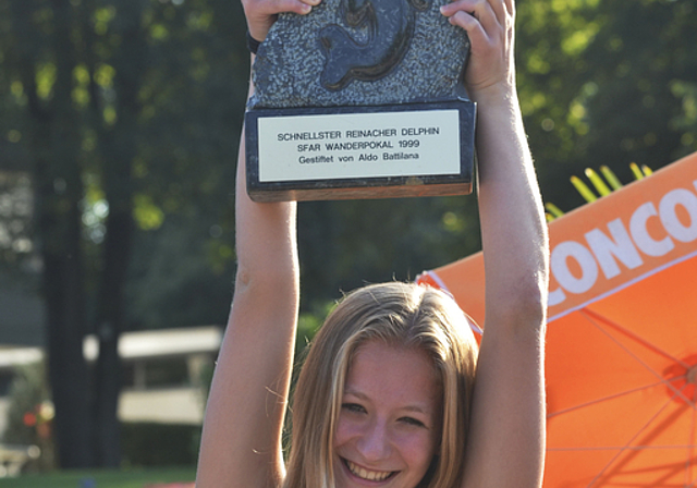 Schnellster Reinacher Delphin 2013: Céline Fille stemmt den 18 Kilogramm schweren Wanderpokal aus Puschlaver Serpentin.  Foto: Manuel Galle