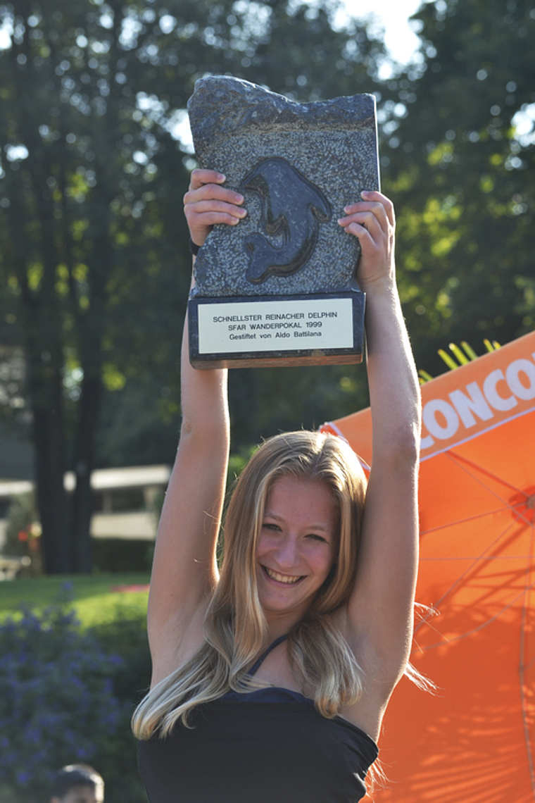 Schnellster Reinacher Delphin 2013: Céline Fille stemmt den 18 Kilogramm schweren Wanderpokal aus Puschlaver Serpentin. Foto: Manuel Galle