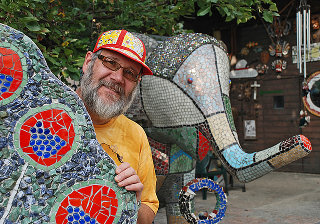 Glitzernd und farbenfroh: Markus Moser zwischen seinen Figuren. Foto: Thomas Brunnschweiler