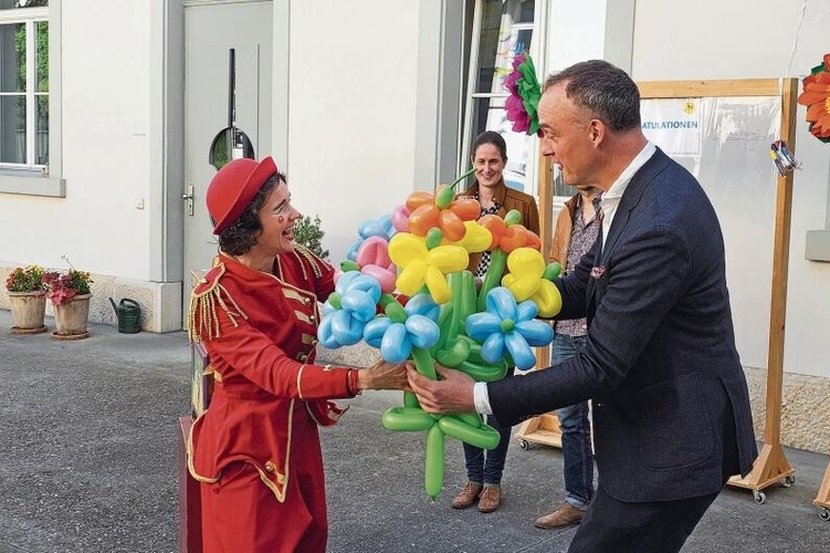 Ein Blumenstrauss der anderen Art: Clownin Milu gratuliert dem Leiter der Regionalen Musikschule Laufental-Thierstein, Lucas Rössner, mit einem bunten Ballon-Strauss. Foto: Melanie Brêchet
