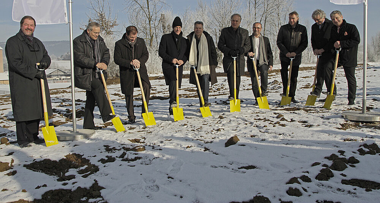 Stechen symbolisch ihren gelben Spaten in den Boden: Die Ricola-Direktoren Giovanni Batzer (l.), Felix Richterich (2. v. l.), Lukas Richterich (5. v. l.), die Architekten Jacques Herzog (4. v. l.), Pierre de Meuron (5. v. r.) und Stadtpräsident Alex