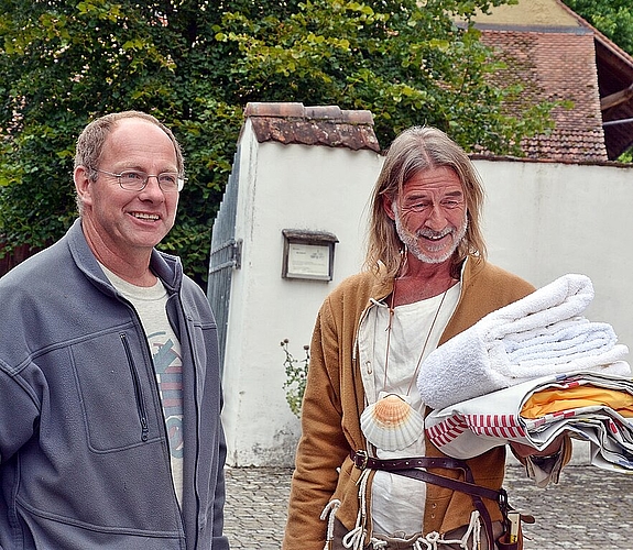 Toller Typ: Der Beinwiler Kirchgemeindepräsident Urs Saner im Gespräch mit dem SRF-Moderator Ralph Wicki, der die Jakobsmuschel des Jakobsweges trägt.