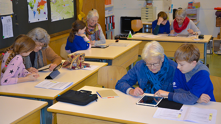Die digitale Welt kennenlernen: Jung und Alt beugten sich im Arlesheimer Dom-Schulhaus über iPads, um gemeinsam dessen Geheimnisse zu erkunden. Foto: Thomas Immoos