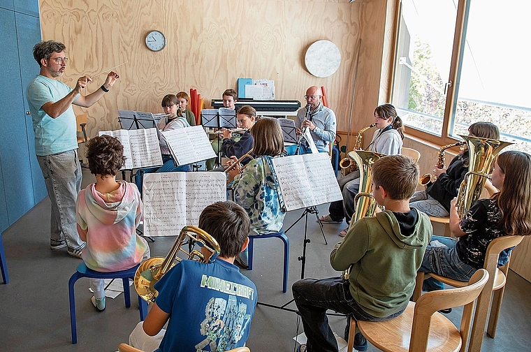 Blasmusikunterricht für alle: Mit Dirigent Martin Altenbach, Lehrer Marc Schwald (hintere Reihe, 3. v. l.) sowie den Schülerinnen und Schülern (vier sind an diesem Tag abwesend). Foto: Martin Staub