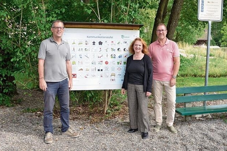Gemeinsam engagiert: (v. l.) Gemeindepräsident Markus Eigenmann sowie die Präsidentin und der Geschäftsleiter der Vereinigung Cerebral Basel, Christine Menz und Beat Loosli, vor der neuen Kommunikationstafel. Foto: Mirjam Sinniger