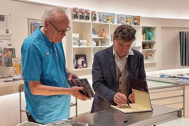 Freundlich und nahbar: Christopher Lehmpfuhl signiert ein Buch zur Ausstellung.