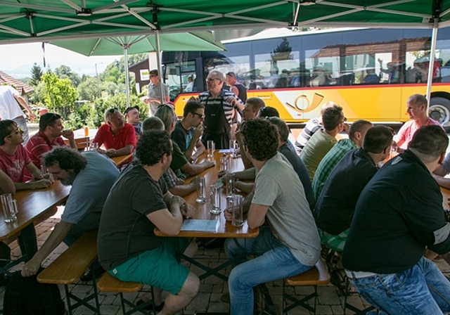 Ein Fest für die Freunde spezieller Biere: Gilbert Oberson (mit Schürze) bringt seinen Gästen die Philosophie des Bierbrauens näher. Das PostAuto im Hintergrund fährt eine Gruppe vom Bierhüsli Himmelried zur nächsten Kleinbrauerei, während di