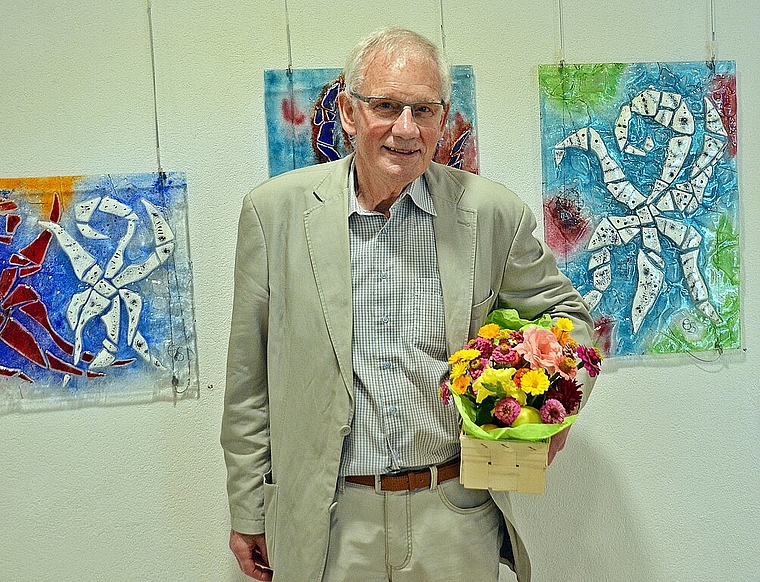 Verdiente Blumen für sympathischen Künstler: Emil «Migger» Simonetti vor seinen «beglückten und swingenden» Laufen- und Liestal-Stäben in Glasfusing. Foto. Roland Bürki