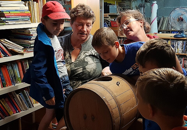 Neugierig: Christine Cueni erklärt den Kindern, was ein Butterfass ist. Foto: Melanie Brêchet