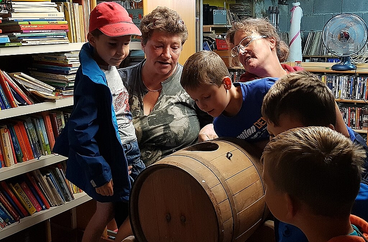Neugierig: Christine Cueni erklärt den Kindern, was ein Butterfass ist. Foto: Melanie Brêchet