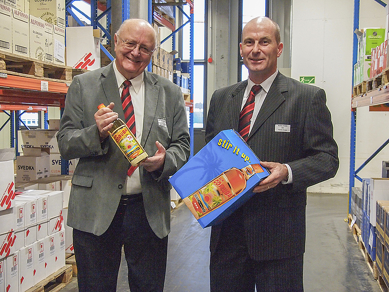 Von der Karibik in den Kägen und von da in die Hausbar: Verwaltungsratspräsident Peter Haecky (links) und CEO Markus Wehrli zeigen mit dem Coruba-Rum eines ihrer bekanntesten Importprodukte. Foto: Tobias Gfeller