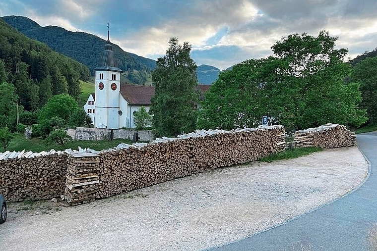 Erzürnt einige Kirchgänger: Das entlang des Parkplatzes gelagerte Holz für die zukünftige Heizung des Klosters. Foto: Bea Asper