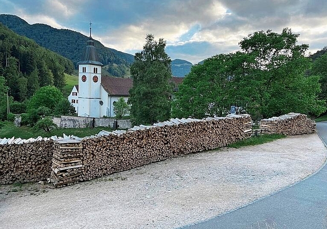 Erzürnt einige Kirchgänger: Das entlang des Parkplatzes gelagerte Holz für die zukünftige Heizung des Klosters. Foto: Bea Asper