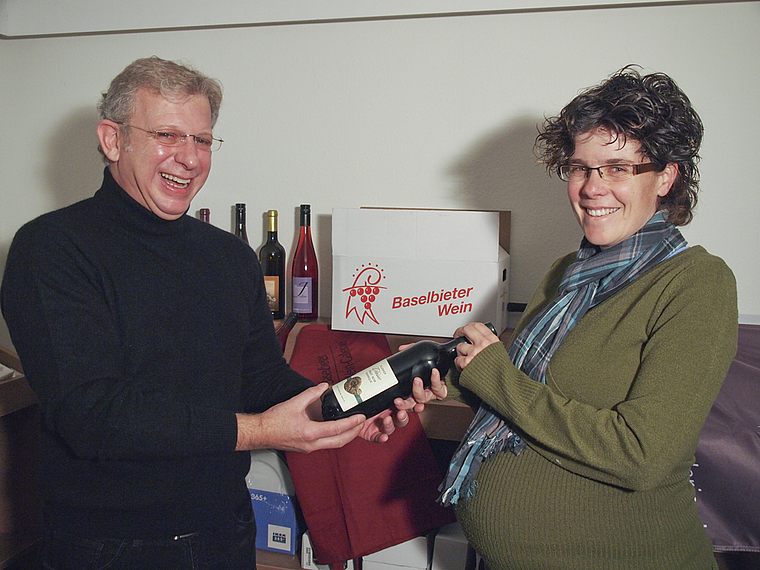Liebhaber trifft Produzentin: Winzerin Barbara Koellreuter vom Klushof überreicht ihren Wein Philipp Meder, Initiant und Geschäftsführer der Baselbieter Wein-Galerie an der Hauptstrasse 55. Foto: Tobias Gfeller