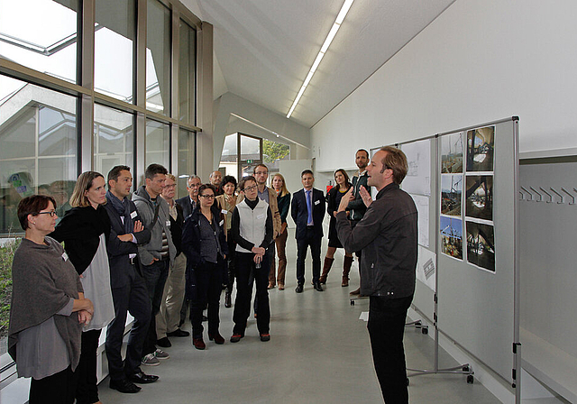 Der Architekt erklärt sein Werk: Peter Baumberger (r.) bringt den Gästen das neue Schulhaus näher. Mitarchitekten Daniel Kaschub und Claudia Freiburghaus (2. und 3. v. r.) sowie Stadtpräsident Alex Imhof (4. v. r.) begleiten den Rundgang.  Fotos: