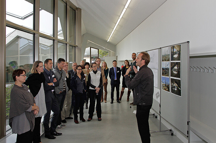 Der Architekt erklärt sein Werk: Peter Baumberger (r.) bringt den Gästen das neue Schulhaus näher. Mitarchitekten Daniel Kaschub und Claudia Freiburghaus (2. und 3. v. r.) sowie Stadtpräsident Alex Imhof (4. v. r.) begleiten den Rundgang. Fotos:
