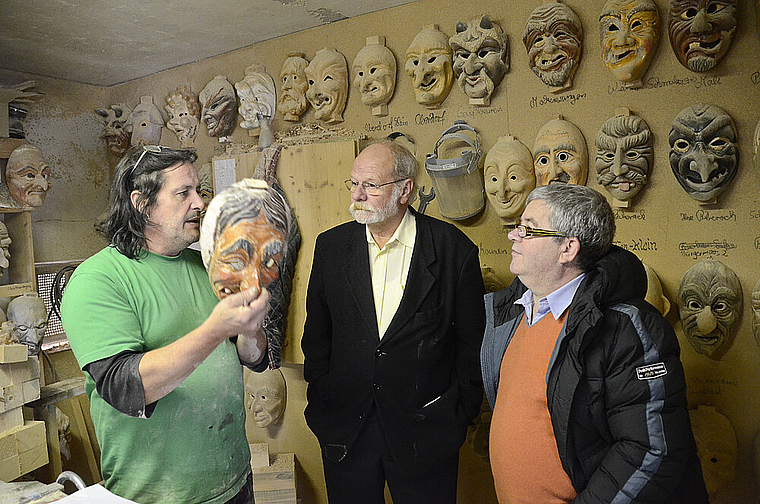 Umgeben von Fratzen: Der Maskenschnitzer Jogi Weiss, André Sprecher und Alex Meyer von der Zunft zu Rebmessern (v. l.). Foto: h. Leuthardt