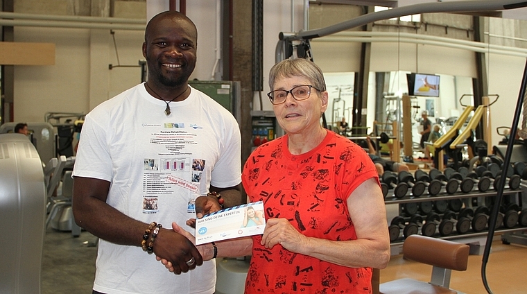 Preisübergabe: Dy Toudjip Kouamo überreicht Regina Kohler ein Dy-Fit-Trainingsabo.
