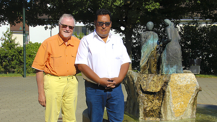 Verbundenheit über die Jahrzehnte: Pfarrer Bernhard Schibli und Edwin Poire, Direktor von «FEDERH Fe y Derechos Humanos – Glaube und Menschenrechte» vor dem Bronzebrunnen, der auch als Nachbildung in Peru steht. Foto: Tobias Gfeller