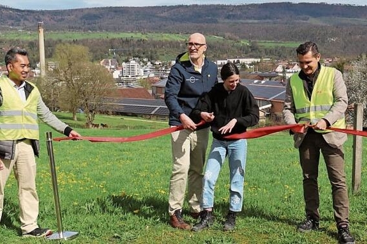 Symbolischer Akt: Michael Hohn, Mitbegründer und VR-Präsident der Swiss Solar City AG (2.v.l.), und Michael Fritschi, Geschäftsführer der Zürcher Ziegelei AG (r.), bei der Einweihung der Photovoltaikanlage auf der Ziegeleifabrik (im Hintergrund). Foto: Gaby Walther