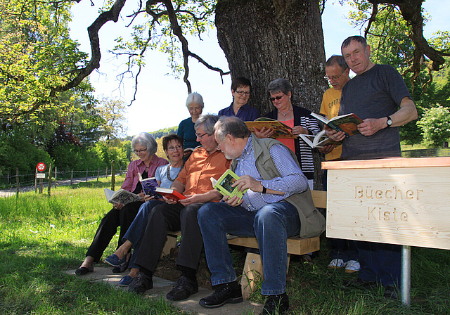 Romantik: Das Team der Bücherbrockenstube und Burgerrat Josef Marquis (rechts) weihen die Lesebank ein.  Foto: Gini Minonzio