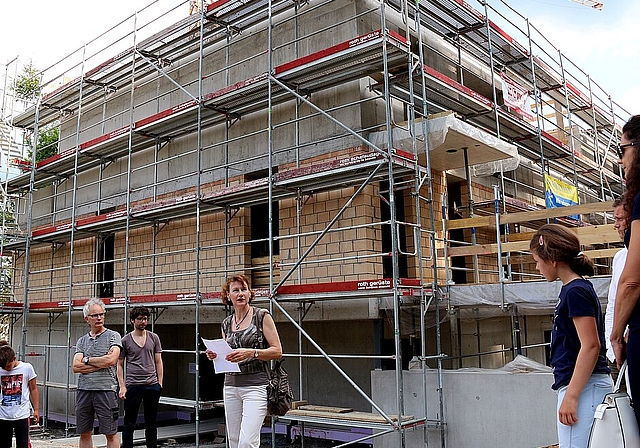 Vor dem Rohbau des Kinder- und Jugendheims: Claudia Weibel, Präsidentin der Baukommission, eröffnet das Aufrichtefest. Foto: Gaby Walther