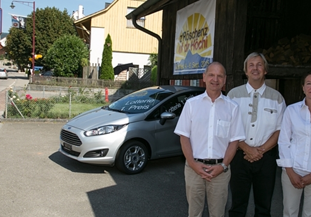 Die Drahtzieher und der Tombola-Hauptpreis: Simon Imhof, OK-Präsident, Remo Oser, Gemeindepräsident, und Nadine Steiner, Programmverantwortliche (v.l.). Im Hintergrund das von der einheimischen Dorfggarage gestiftete Auto, unter dem Logo zum Fest. 