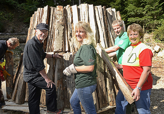 Aufbau des Holzkohlenmeilers: Kreisförster Christian Gilgen, die Assistentin der Köhlerin, Heidi Moy, den Revierförster Christian Becker sowie die Köhlerin Doris Wicki (v. l. ).  Foto Heiner Leuthardt