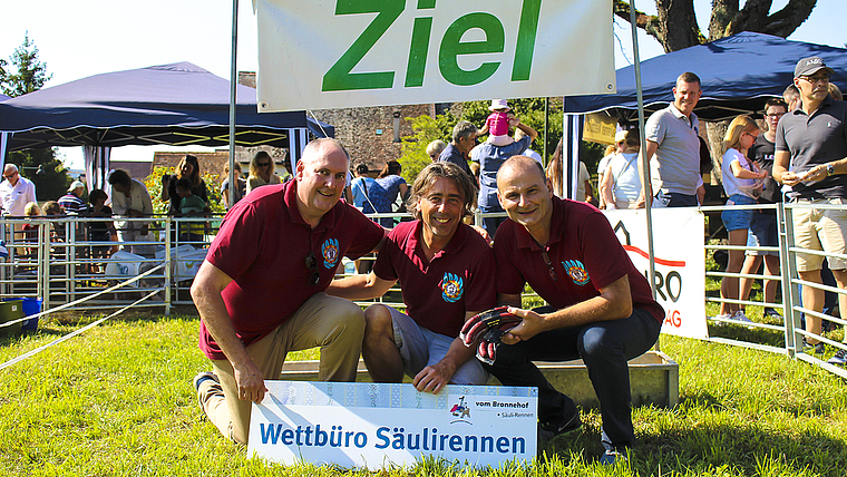 Hatten ein saumässiges Vergnügen: Statthalter Roger Burri, Zeremonienmeister René Piesker und Säckelmeister Andreas Siegfried vor dem Zieltrog des Säulirennens.  Foto: Axel Mannigel