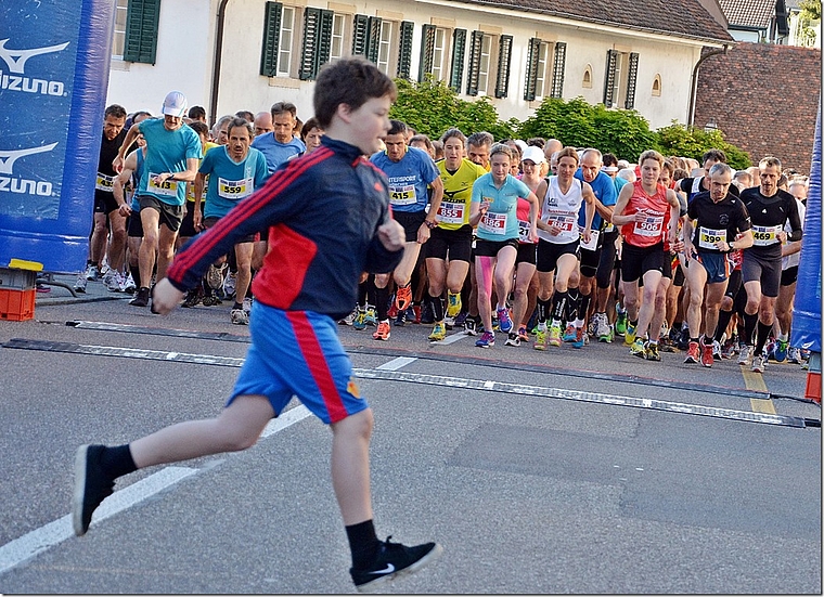 FCB-Sprint: Der junge Fan schafft es noch knapp vor der startenden späteren Siegerin Martina Strähl (886) und der Zweitplatzierten, Bettina Steiger (884), über die Strasse. Foto: Roland Bürki
