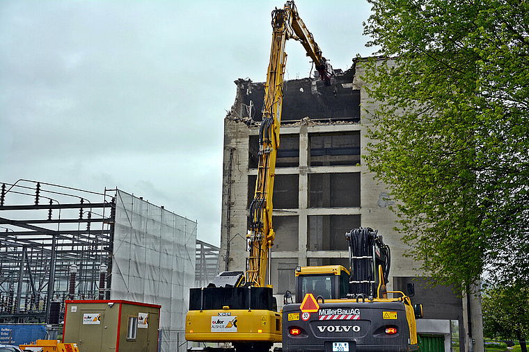 Gefrässig: Mit seinem 27 Meter langen Ausleger bricht der Longfront-Bagger Stück für Stück des Reparaturturms heraus. Foto: Roland Bürki