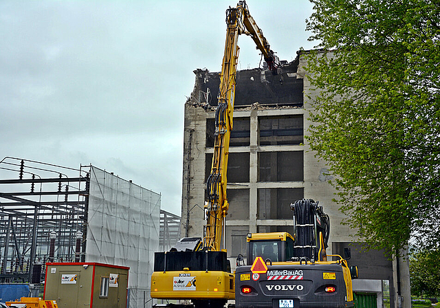 Gefrässig: Mit seinem 27 Meter langen Ausleger bricht der Longfront-Bagger Stück für Stück des Reparaturturms heraus.   Foto: Roland Bürki