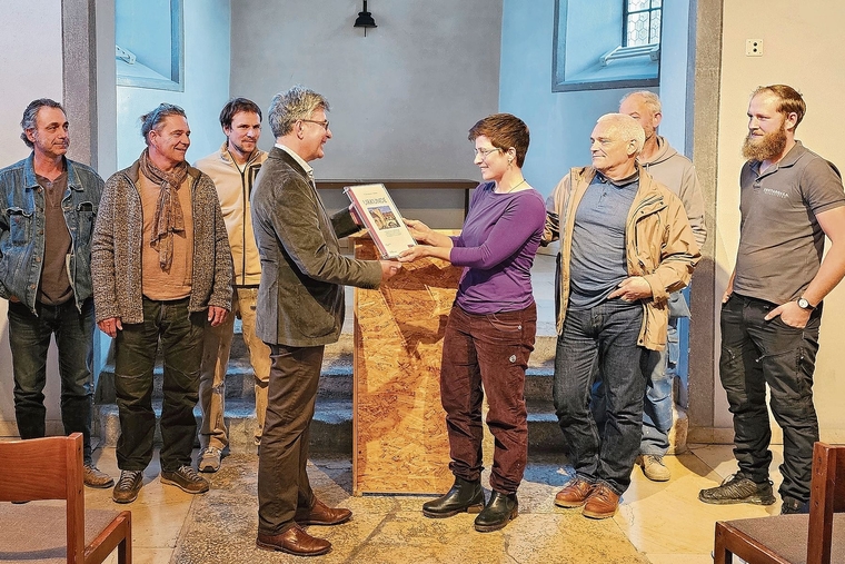Übergabe: Im Kreis ihrer Berufskollegen nimmt Steinbildhauerin Meret Gerber den Preis von Angelo Tomaselli in Empfang. Foto: Melanie Brêchet
