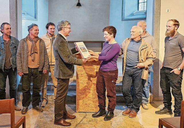 Übergabe: Im Kreis ihrer Berufskollegen nimmt Steinbildhauerin Meret Gerber den Preis von Angelo Tomaselli in Empfang. Foto: Melanie Brêchet