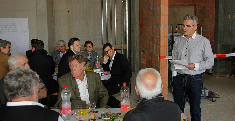 Der Präsident der Baukommission hat das Wort: Felix Nussbaumer (r.). Im Hintergrund Cécile Jenzer, Präsidentin Stiftungsrat (3. v. r.), Architekt Matthias Baumgärtner (4. v. r.) sowie Georges Thüring, Präsident des Verwaltungsrates (5. v. r.).