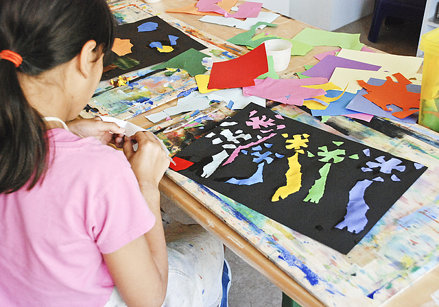 Erinnert irgendwie doch an Matisse: Junge Künstlerin beim Collagieren.  Foto: Thomas Brunnschweiler